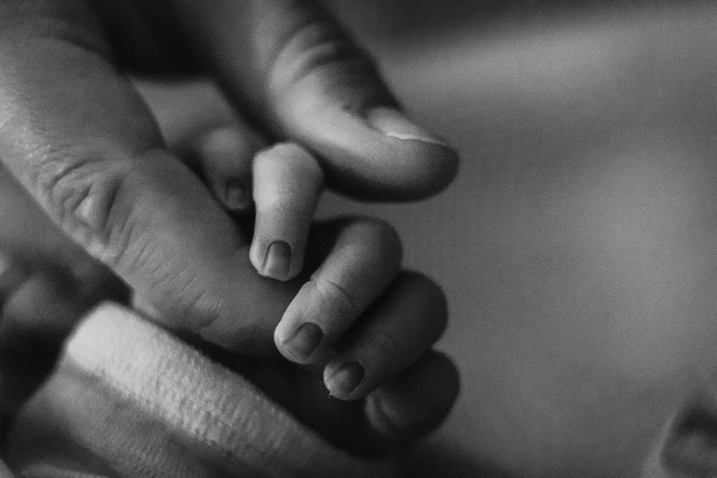 Babyhand umgreift Finger bei Geburtsreportage im Allgäu